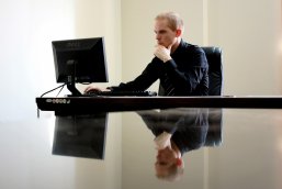 Mann am PC Ein Mann sitzt an seinem Schreibtisch und arbeitet am PC.