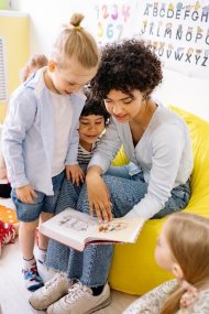 Foto einer Frau, die Kindern ein Buch vorliest