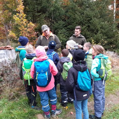 Zwei Jäger sprechen mit einer Gruppe Kindern