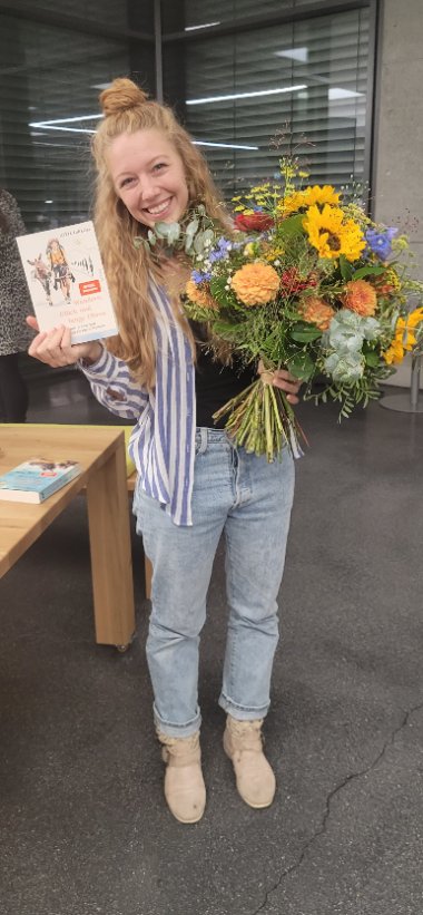 Lotta Lubkoll mit ihrem Buch und einem Blumenstrauß